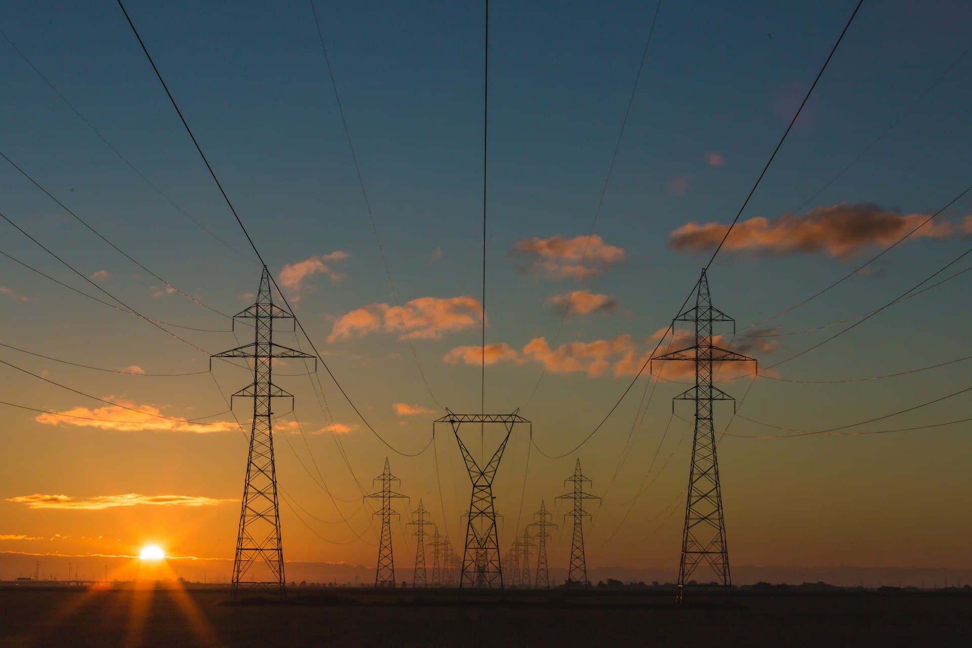 Energy infrastructure across an open landscape at dusk